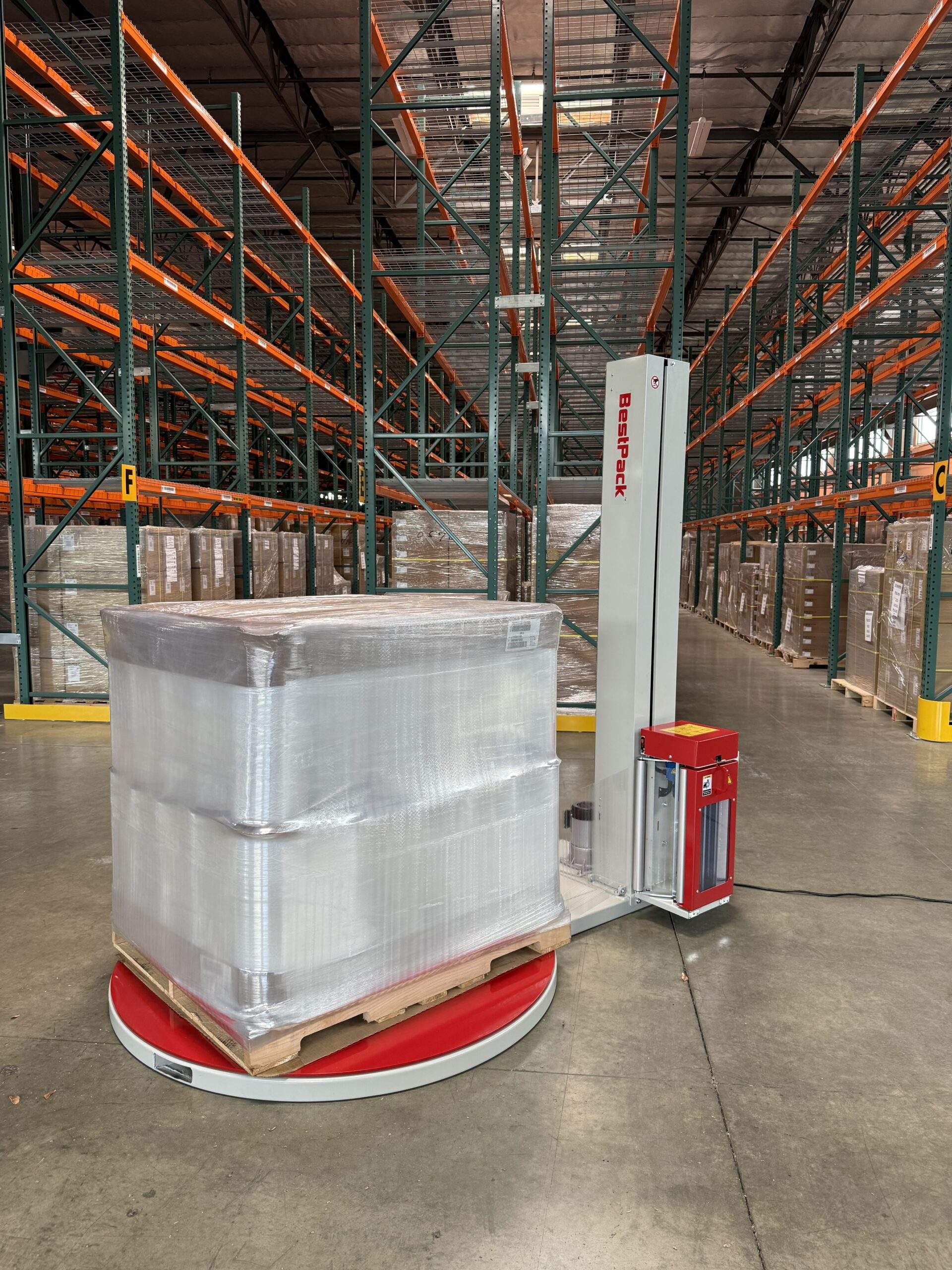 Reference photo of the BestPack S250i pallet wrapper in a warehouse