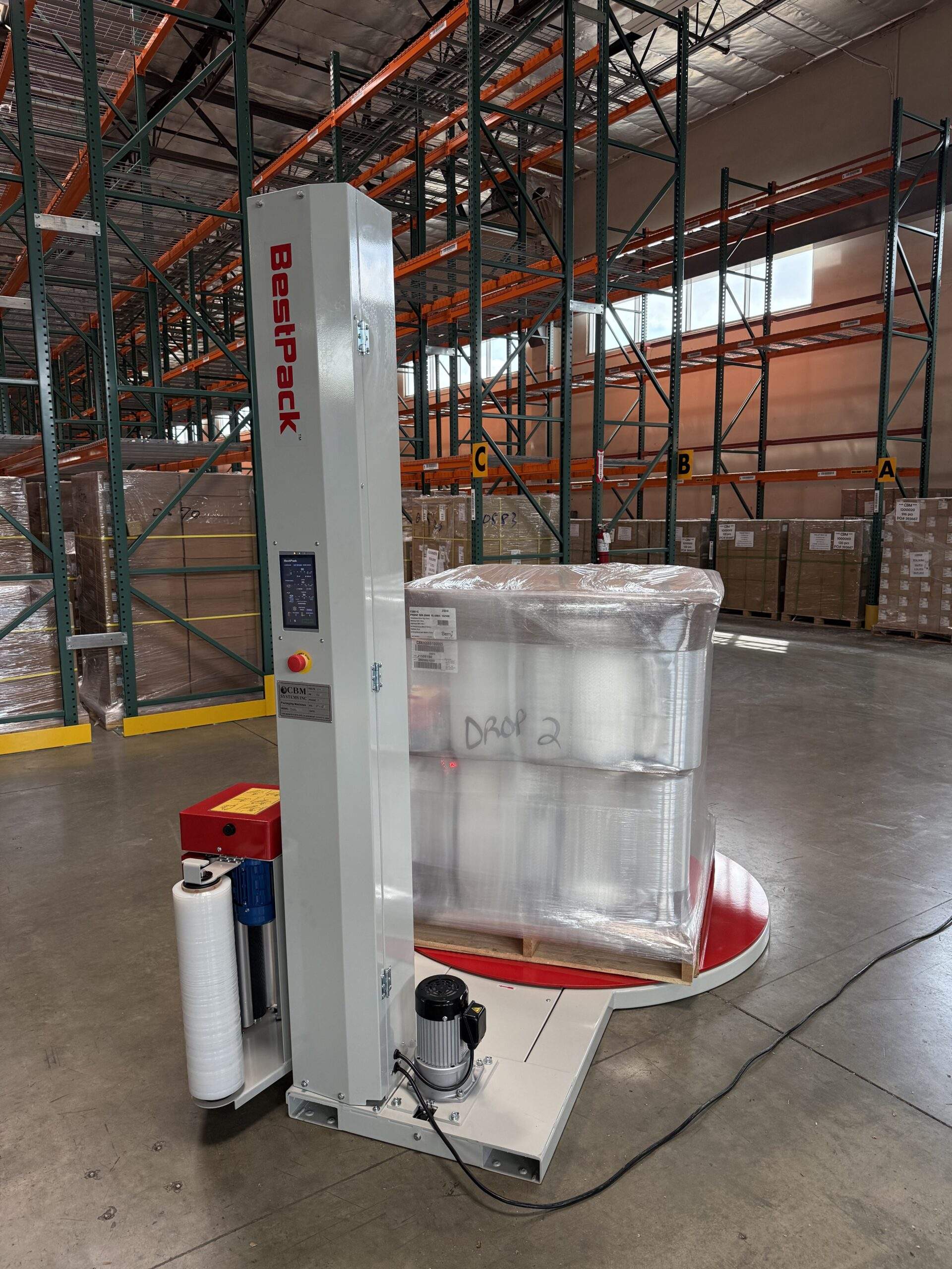 Different angle reference photo of the BestPack CBM Systems S250i pallet wrapper in a warehouse.